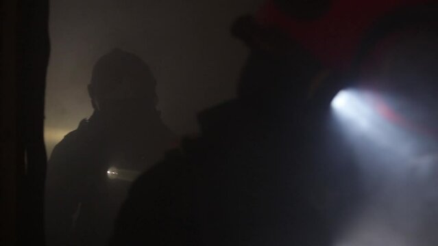 Background image of firefighters moving inside a smoky room. Image without sharpness.