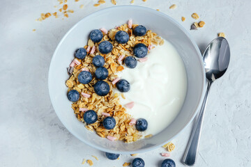 Obraz na płótnie Canvas Yogurt with muesli and berries on a gray background.