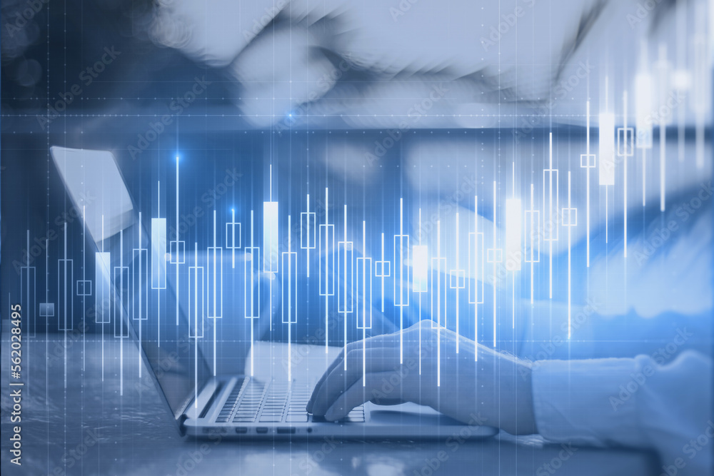 Poster side view of businessman hands using laptop at desktop with glowing blue candlestick chart on blurry
