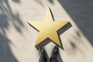 Celebrity, popularity and fame concept with view from top on blank golden star with men boots on sunlit concrete surface, mockup - obrazy, fototapety, plakaty