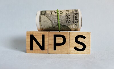 the text NPS Net promoter score on wooden cubes on stacked coins. Business concepts.