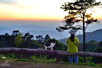 Traveller and her lovely cat waiting for amazing twilight sunset