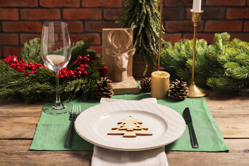 Festive place setting with beautiful dishware, cutlery and decor for Christmas dinner on wooden table