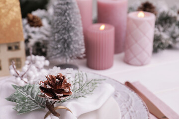 Fototapeta na wymiar Festive place setting with beautiful dishware and cone for Christmas dinner on white wooden table, closeup. Space for text