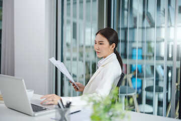 Asian businesswoman working on laptop and mobile phone Start up small business owner. business successful technology concept