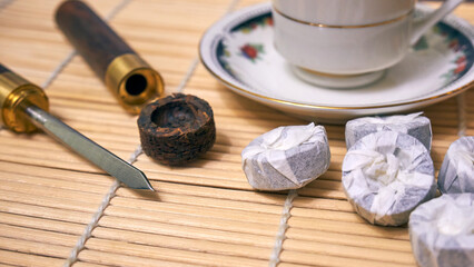 A special knife for the tea ceremony. Pu-erh tea and a knife on a bamboo mat