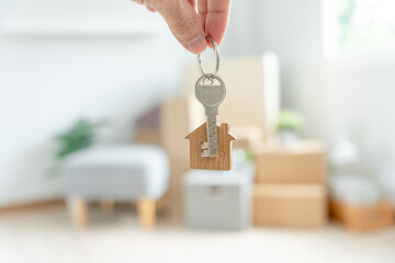 Moving house, relocation. Woman hold key house keychain in new apartment. move in new home. Buy or...