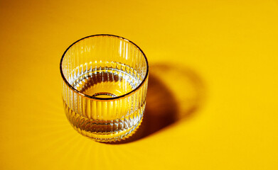 Glasses with water on yellow background with copy space