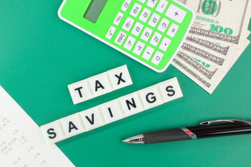 pens, calculators, paper money and receipts with the word tax savings. the concept of tax savings