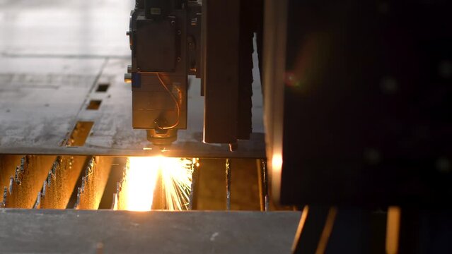 A laser machine cuts a piece of metal.