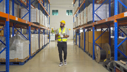 Obraz premium Teamwork of black workers working in large warehouse store industry.Rack of stock storage. Interior of cargo in ecommerce and logistic concept. Depot. People lifestyle. Shipment service for container