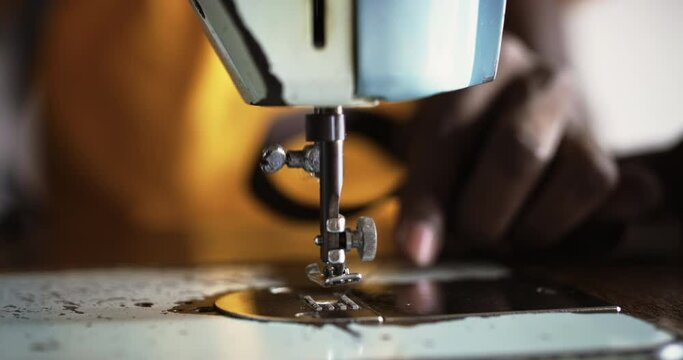 Close Up Footage of an Old Sewing Machine and Black Male Hands Working on it to Fix a Belt. Talented Male Tailor Doing his Job Professionally as He Sews a Customer's Piece of Clothing 