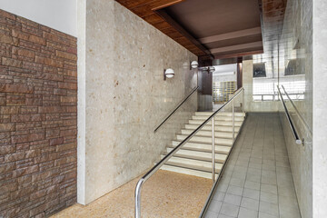Entrance of a house with long corridor, stairs to elevator area with ramp for disabled person...