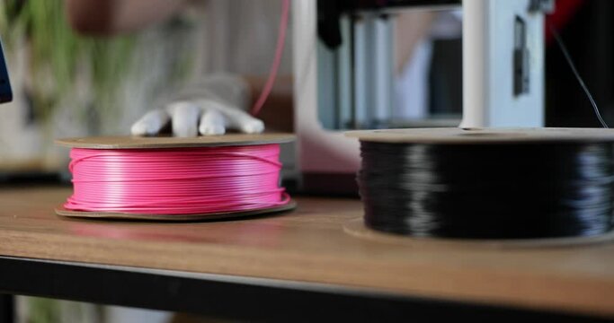 Worker unwinding spool of plastic for 3d printer closeup 4k movie slow motion 