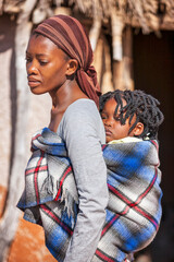 village african mother carrying her child in the back