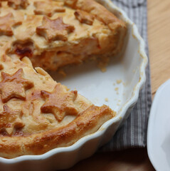 Cut Italian Timballo or Timbale filled with pasta and bechamel with tomato sauce on wooden table