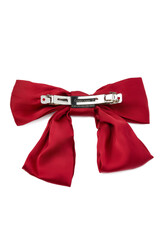 Detailed shot of a hair clip decorated with a large red soft fabric bow. The fancy bright hair accessory is isolated on the white backdrop. Back view.