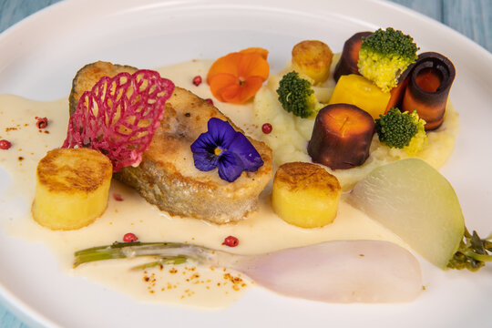 Recipe of cod steak, mashed potatoes and its farandole of vegetables, parsnip, turnip, broccoli, candied potato. High quality photo
