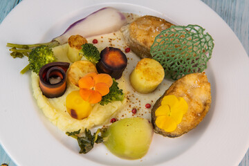 Recipe of cod steak, mashed potatoes and its farandole of vegetables, parsnip, turnip, broccoli, candied potato. High quality photo