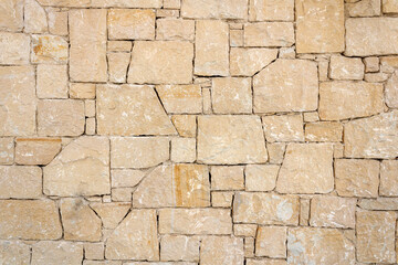 Texture of old rough geometric shapes natural stone wall  