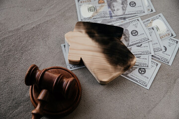 Dollar bills, burn house and gavel. Law and fire insurance concept