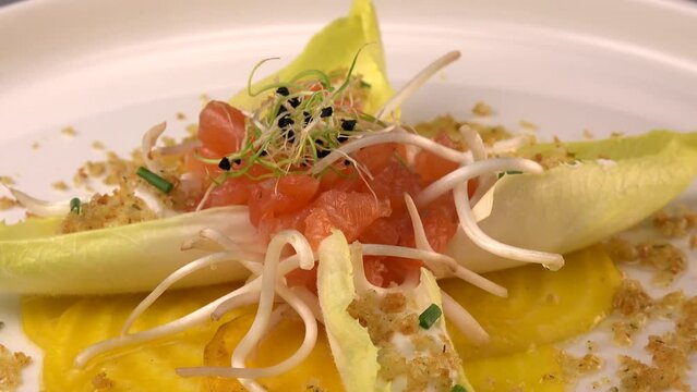 Recipe for salmon gravlax salad, endives filled with creame fresh, chives, yellow chioggia beetroot and leek shoots, white balsamic vinegar sauce. High quality video