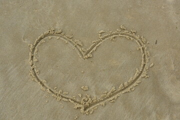 Fototapeta na wymiar heart carved on the sand of a beach