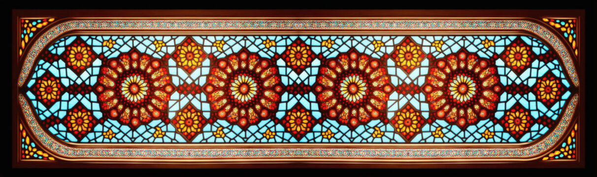 horizontal arabesque pattern with mosaic glass style window, in red and orange back lit colors