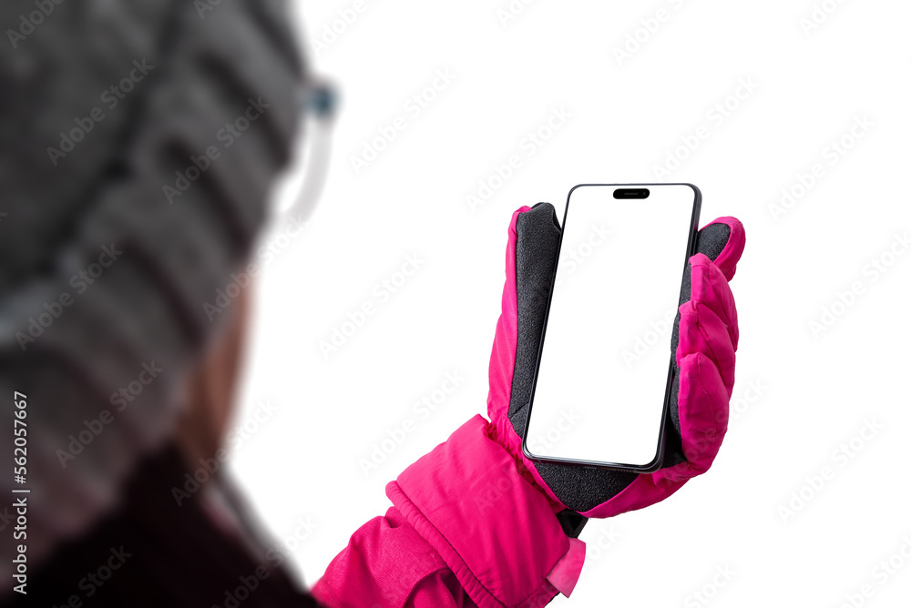 Poster Girl holds a mobile phone in ski gear.. Pink winter jacket with gloves and hat. Concept of using a phone on a ski slope; Isolated display and background for the presentation of apps and web pages