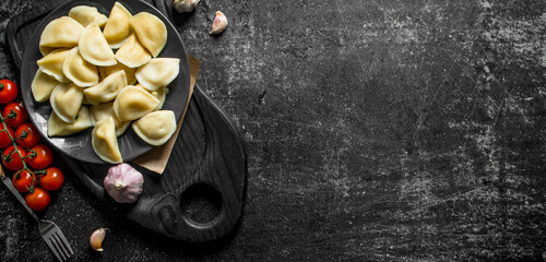 Dumplings on a plate and cherry tomatoes.