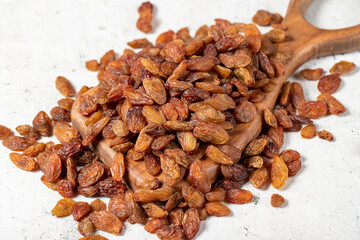 Raisins on a wooden serving board on a stone background. Large raisins dried in the sun. close up