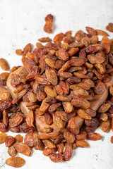 Raisins on a wooden serving board on a stone background. Large raisins dried in the sun. close up