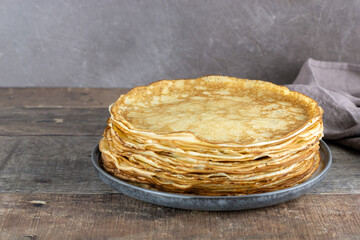 A stack of french crepes, pancakes or Russian bliny on a wooden background. Close-up. Copy space.