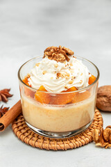 Pumpkin parfait with nuts in glass on a light background. place for text, top view