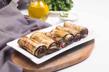 Baked grilled eggplant rolls with cottage cheese, tomatoes and sour cream. Georgian cuisine. 