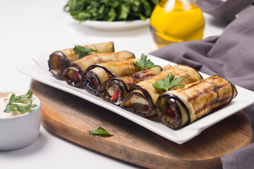 Baked grilled eggplant rolls with cottage cheese, tomatoes and sour cream. Georgian cuisine. 