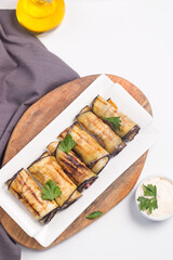 Baked grilled eggplant rolls with cottage cheese, tomatoes and sour cream. Georgian cuisine. 
