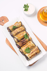 Baked grilled eggplant rolls with cottage cheese, tomatoes and sour cream. Georgian cuisine. 