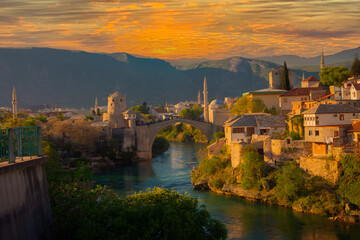 Fantastic Skyline of Mostar with the Mostar Bridge, houses and minarets, at sunset. Location:...