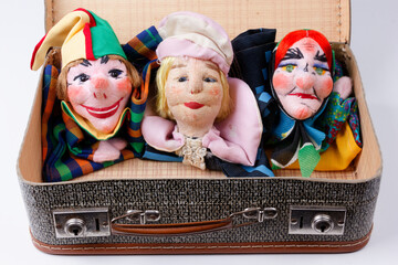 some punch puppets sitting inside a vintage suitcase