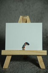 niature people toy figure photography. Women standing above wooden stand on blank desk calendar. Grey cloudy background