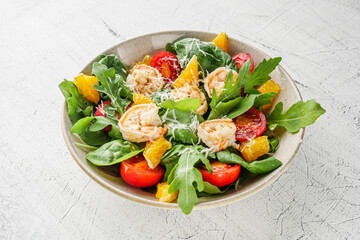 delicious fresh shrimp salad with orange and cherry tomatoes on a white background