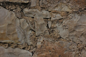 Background of an ancient brick wall, consisting of different stones and pieces of marble
