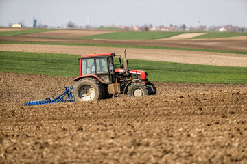 The rhythm of the land, tractor cultivating the fields in harmony with nature