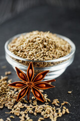 aromatic dry anise seeds on a dark black stone background