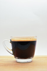 glass of hot black coffee put on wood background