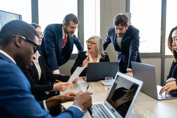 Multiracial business team working together and sharing achievement, senior female boss explaining strategy to specialist, trading and stock asset business concept