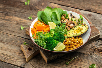 Green vegetable vegan salad with avocado, mushrooms, broccoli, spinach, chickpeas, pumpkin. Healthy vegetarian food concept. top view