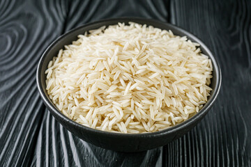 raw basmati rice on a black wooden background