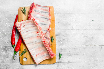 Raw ribs with hot chili peppers and rosemary .